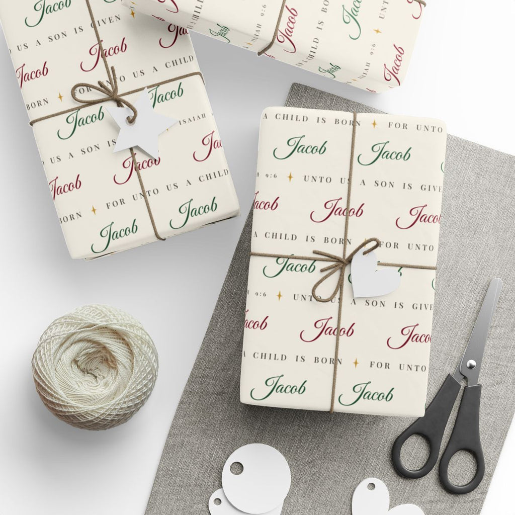 Gifts wrapped in personalized Isaiah 9:6 scripture Christmas paper in ivory with the name Jacob, tied with twine
