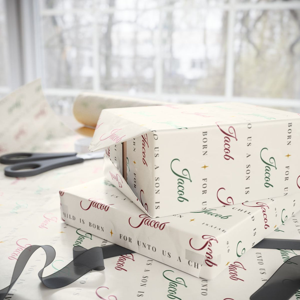 Two gifts wrapped in personalized Isaiah 9:6 scripture Christmas paper in ivory with the name Jacob, on a table by the window