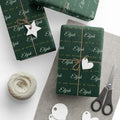 Gifts wrapped in personalized Luke 2:14 scripture Christmas paper in evergreen and gold with the name Elijah, tied with twine