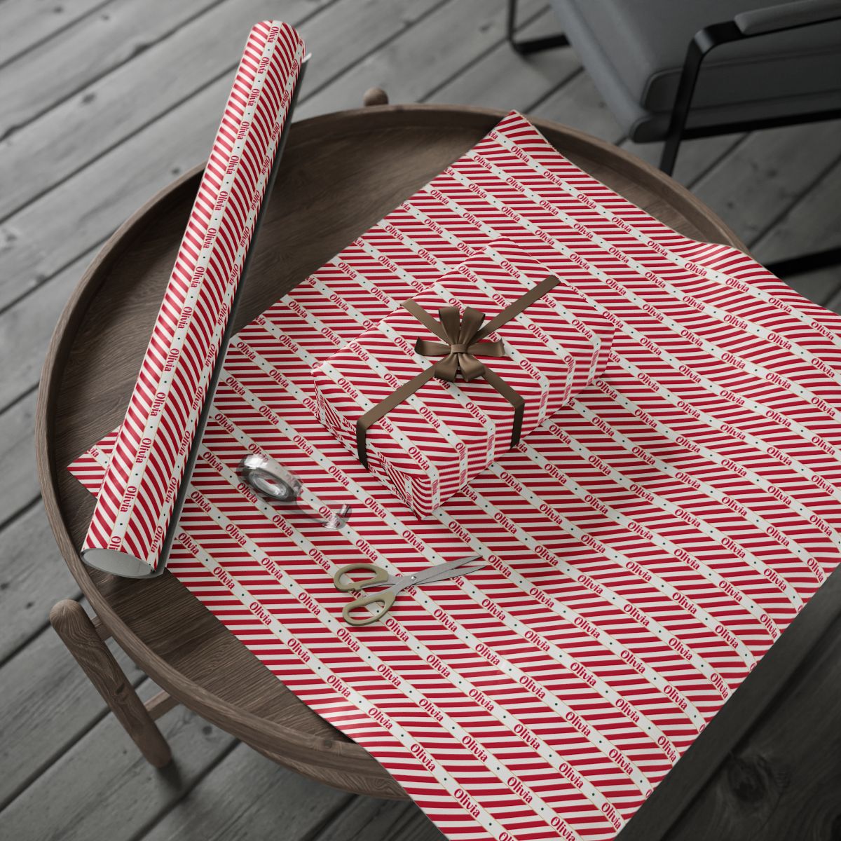 Personalized candy cane wrapping paper roll and a wrapped gift on a wooden table