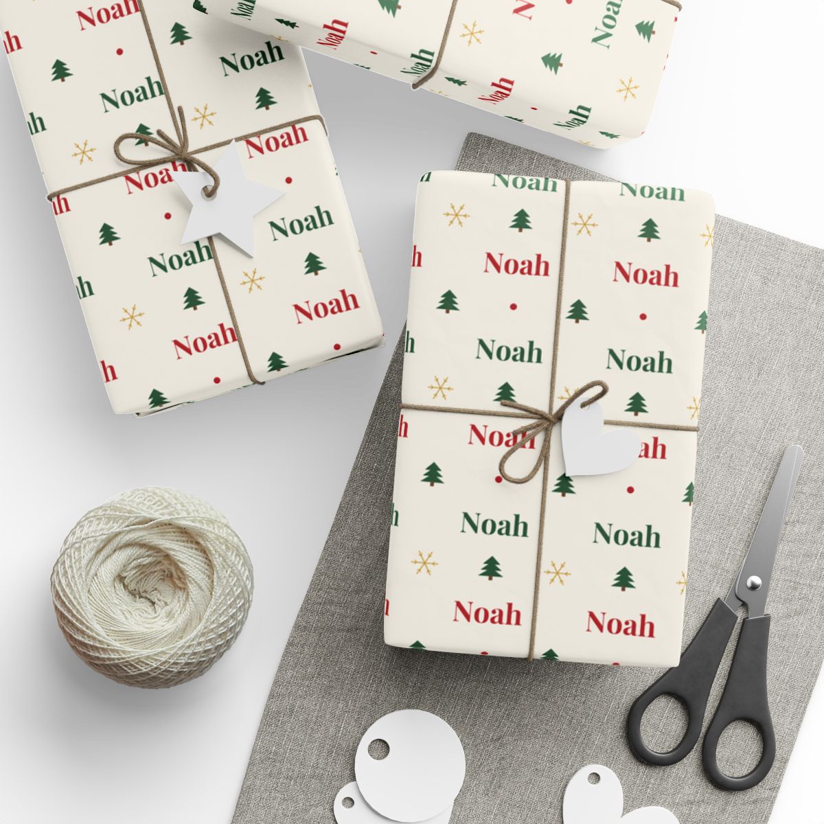 Gifts wrapped in personalized classic name Christmas paper with the name Noah in red and green, tied with twine