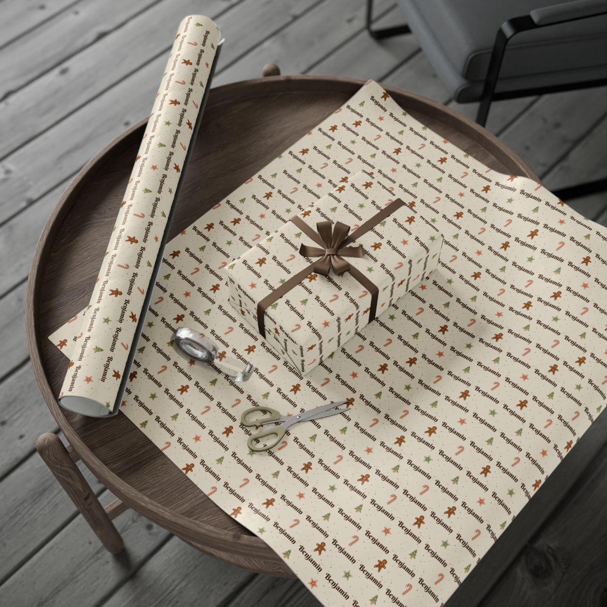 Personalized Christmas cookies paper in cream: the roll and a wrapped gift on a wooden table