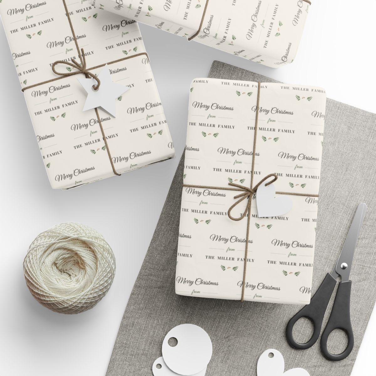 Gifts wrapped in personalized farmhouse Christmas paper reading Merry Christmas from The Miller Family, tied with twine