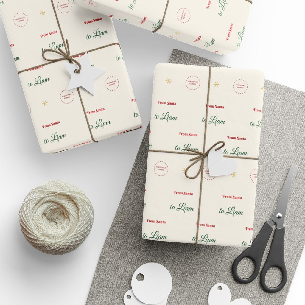 Gifts wrapped in personalized From Santa Christmas paper reading From Santa to Liam, tied with twine