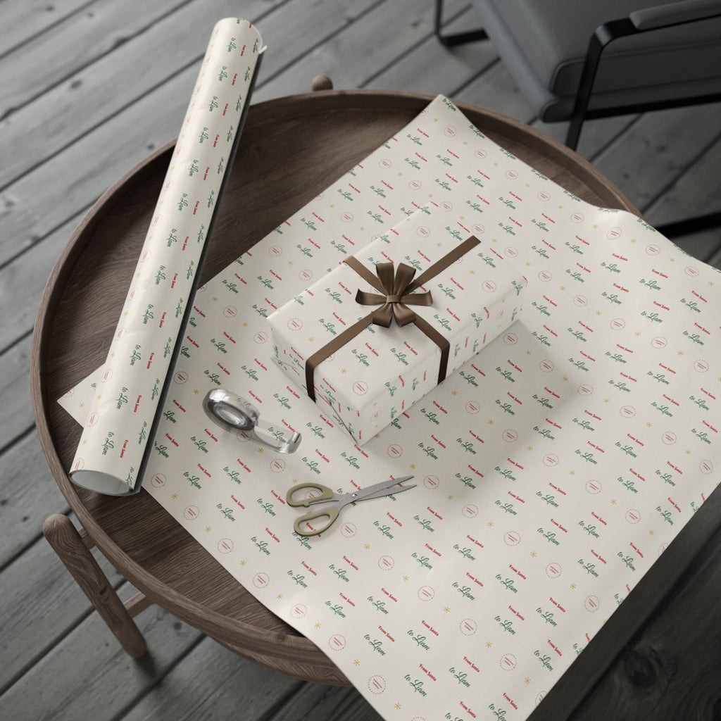 Personalized From Santa wrapping paper roll and a wrapped gift on a wooden table