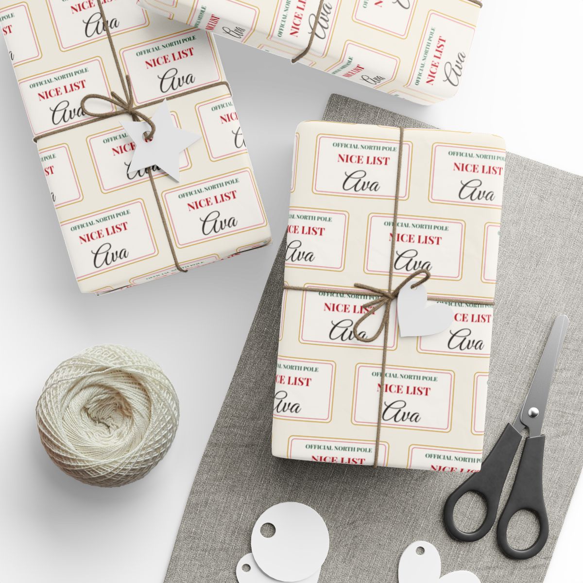 Gifts wrapped in personalized Nice List Christmas paper with the name Ava on every card, tied with twine