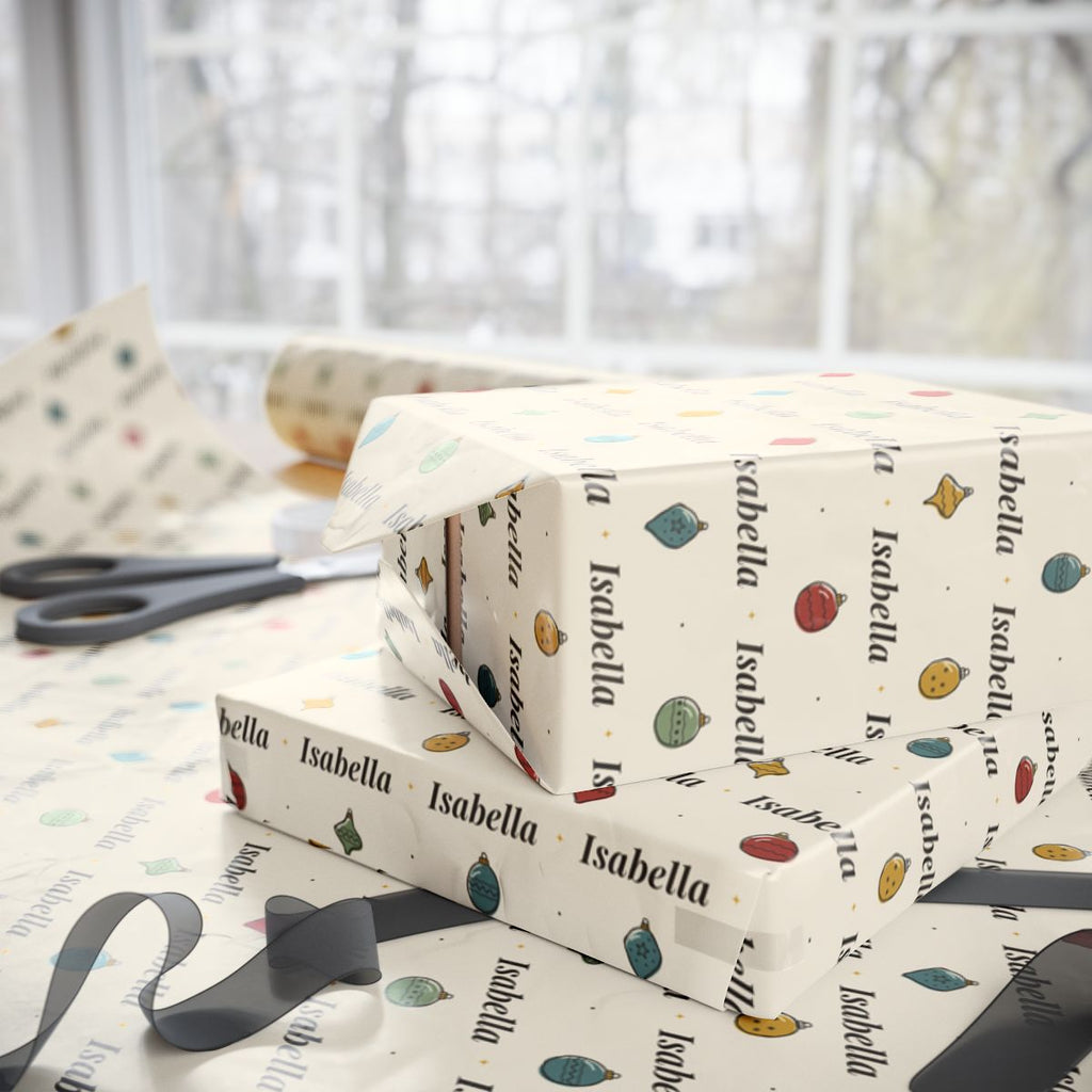 Two gifts wrapped in personalized hand-drawn ornaments Christmas paper with the name Isabella, on a table by the window