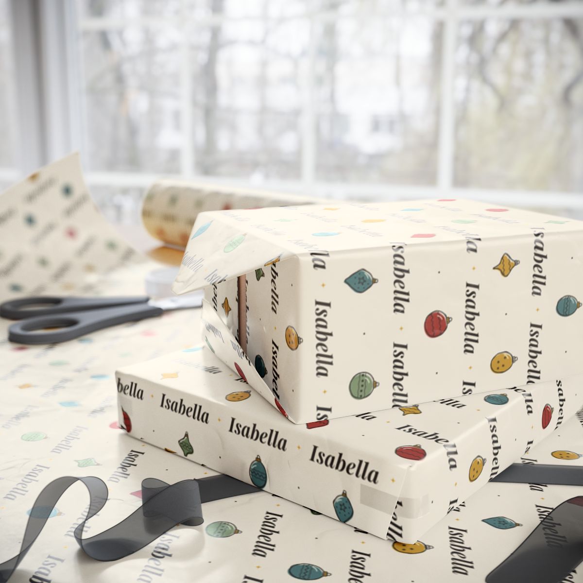 Two gifts wrapped in personalized hand-drawn ornaments Christmas paper with the name Isabella, on a table by the window