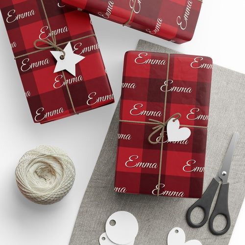 Gifts wrapped in personalized buffalo plaid Christmas paper with the name Emma, tied with twine