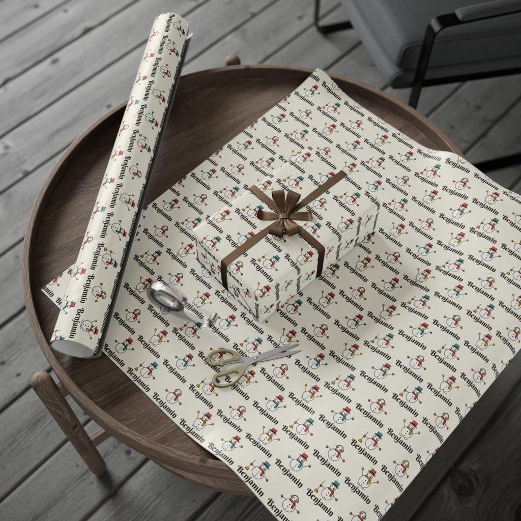 Personalized snowman parade Christmas paper: the roll and a wrapped gift on a wooden table