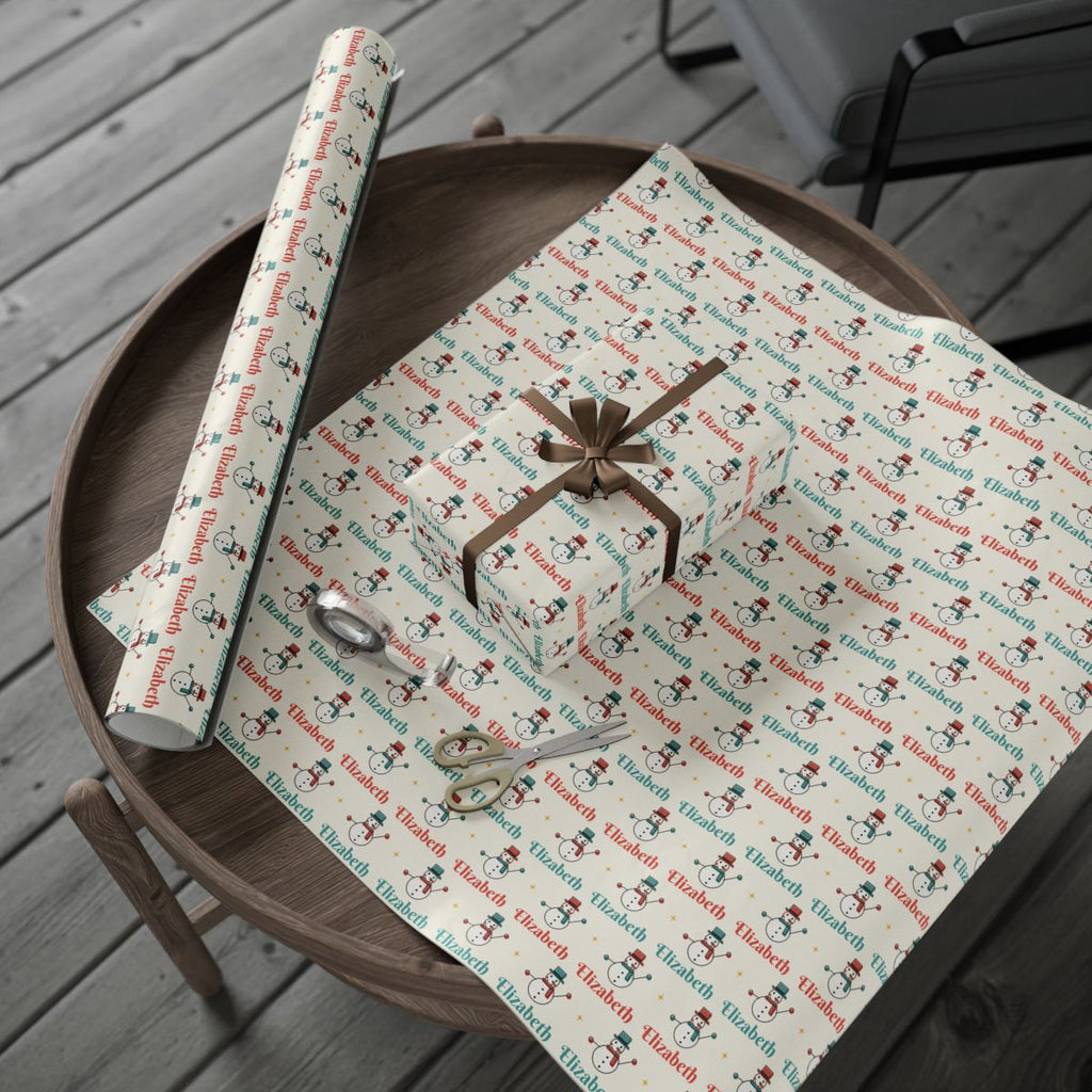 Personalized retro snowman Christmas paper: the roll and a wrapped gift on a wooden table